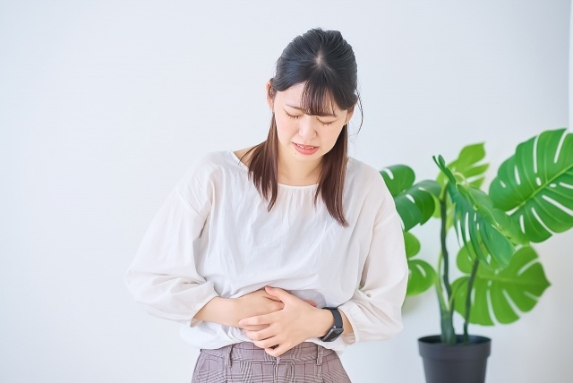 お腹が辛い女性のイラスト